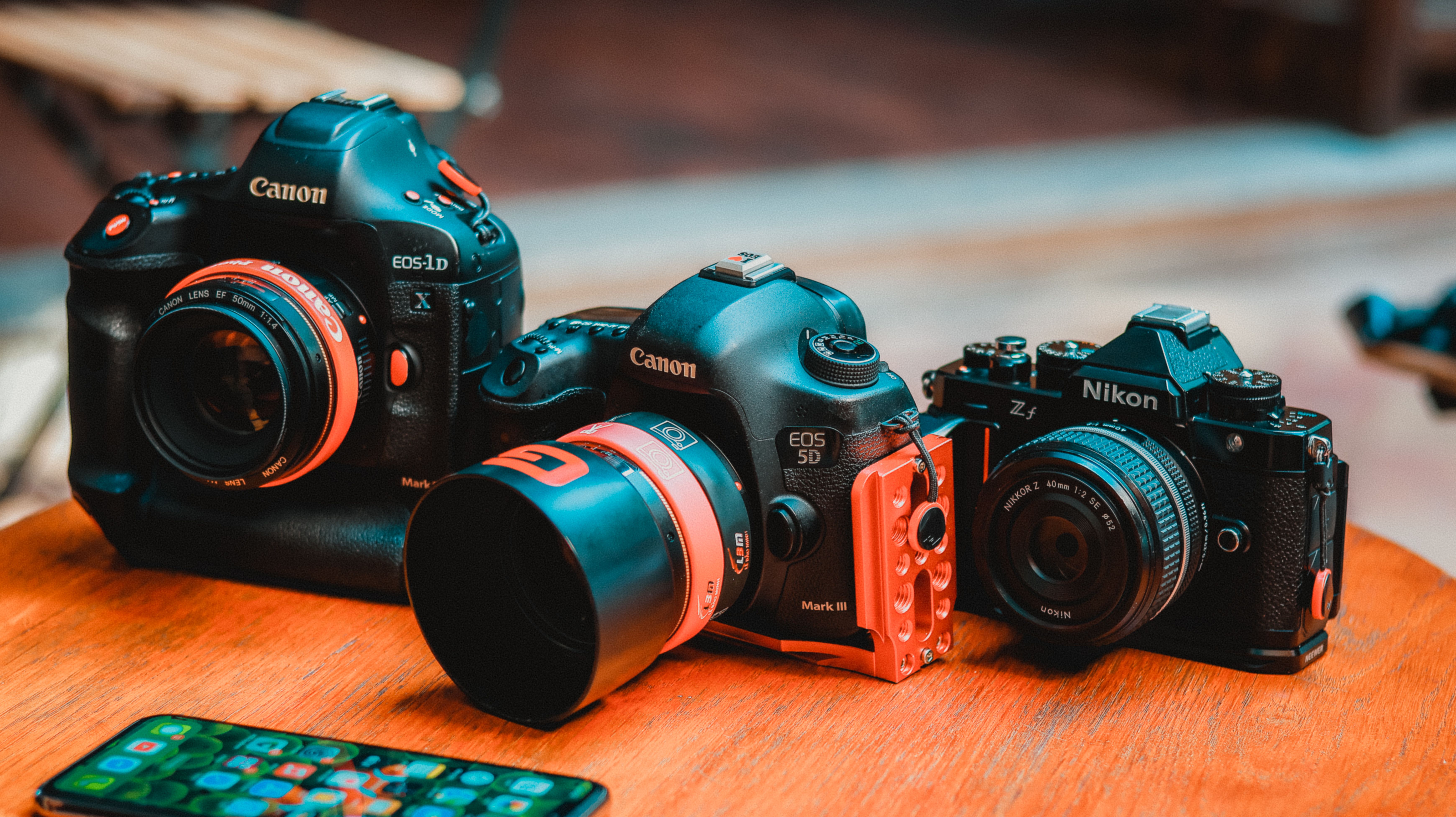 Canon and Nikon cameras on a wooden table